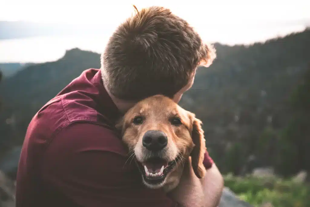 Maitre et chien qui se font un câlin  