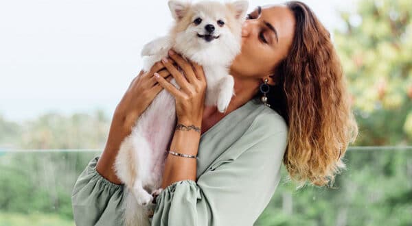 Un chien et sa propriétaire qui font un câlin